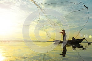 Silhouette of fishermen using coop-like trap catching fish in lake with beautiful scenery of nature morning sunrise. Beautiful sce