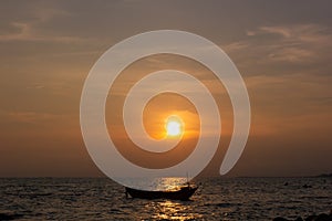 Silhouette of a fishing boat in the middle of the picture, in the evening there is a sunset at the sea