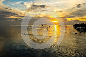 Silhouette of fishing boat in sea at sunrise