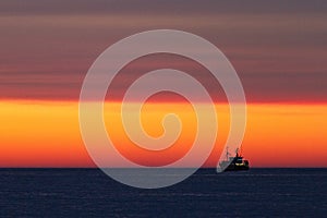 Silhouette of fishing-boat during sunset