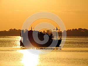 Silhouette of a fishing boat at sunset