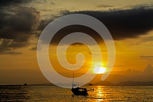 Silhouette of fishing boat at sunset on sea beach resort in Thailand, Krabi