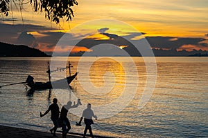 Silhouette fishing boat with unidentified silhouette people