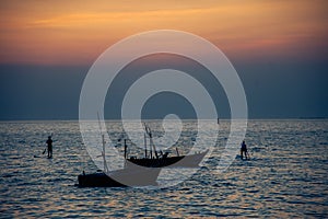 Silhouette of fishing boats against sunset
