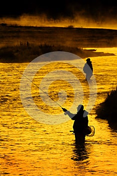 Silhouette of Man Flyfishing Fishing in River Golden Sunlight photo
