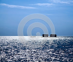 Silhouette fishing little house on the ocean