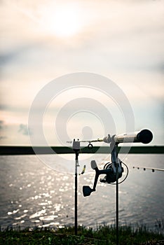 Silhouette of a fishing rod with focus on the reel