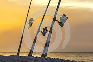 Silhouette of fishing rod with reels at sunset. Fishing equipment.