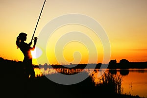 Silhouette of a fishing woman at dawn
