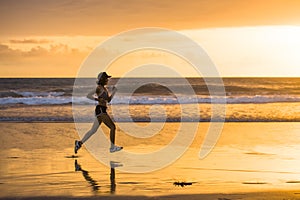 Silhouette of fit and athletic Asian Chinese sporty woman running on beautiful beach doing jogging workout on sunset in fitness he