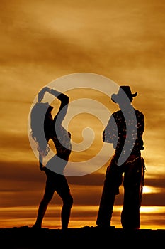 Silhouette of a fit woman standing back with a cowboy