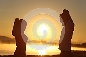 Silhouette of a fitness couple stretching at sunrise