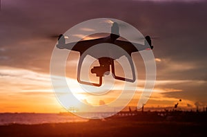 Silhouette of flying drone in sunset time.
