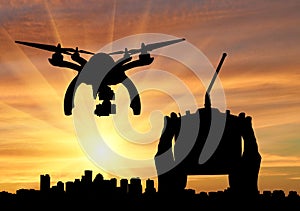 Silhouette flying reconnaissance drone over city and hand remote control