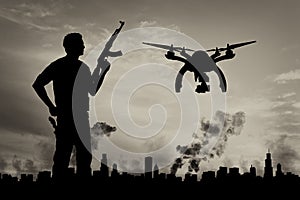 Silhouette flying reconnaissance drone over city in a smoke and a terrorist