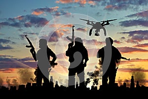 Silhouette flying reconnaissance drone over city in a smoke and a terrorists photo