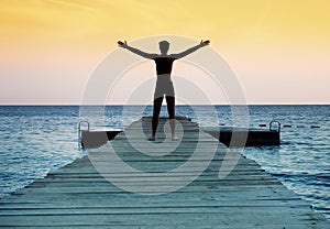 Silhouette of free peaceful man at sunset photo