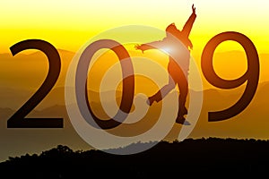 Silhouette of freedom happy young woman jumping on on the hill with New year 2018 concept in sunset background