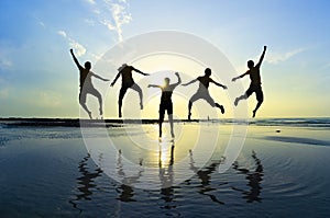 Silhouette of friends jumping over sun