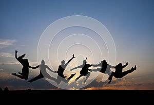 Silhouette of friends jumping in sunset