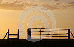 Silhouette gate and stile at sunset