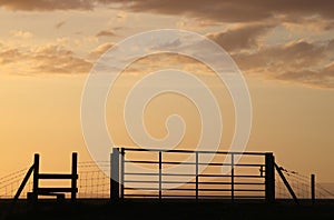 Silhouette gate and stile at sunset