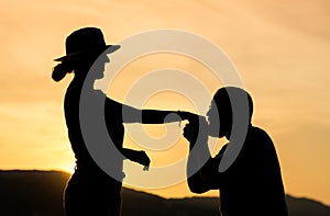 Silhouette of a gentleman kissing hand of his date