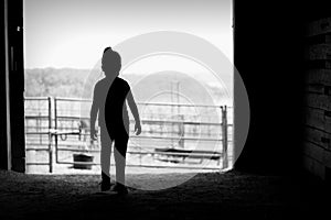 Silhouette of girl in barn door
