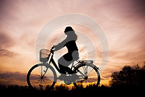 Silhouette of the girl on bicycle