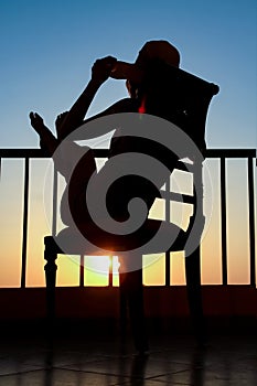 Silhouette of a girl on a chair on a nature background