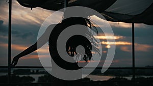 Silhouette of girl dancer at sunset - pole dance, slow-motion