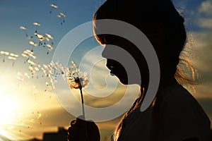 Silhouette of a girl with dandelions