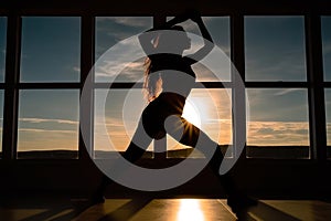 silhouette of a girl is engaged in fitness against the backdrop of the evening window sun generative ai