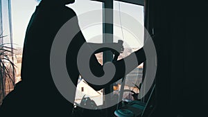 Silhouette of the Girl Exercising on the Cardio Trainer Cross Trainer at Home on Against the Window.