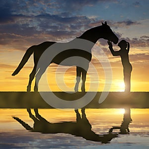 Silhouette of a girl giving a kiss horse