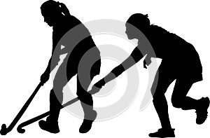 Silhouette of girl hockey players battling for possession