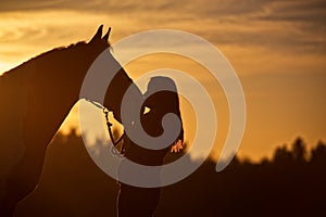 Silhouette of Girl Kissing Horse photo