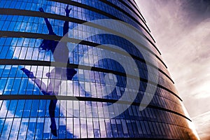 Silhouette of a girl, in the pose of a jumping ballerina on the facade of a skyscraper, with outstretched arms in the form of