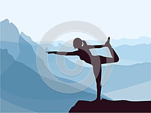 Silhouette of girl practicing yoga. Blue mountains in background