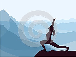 Silhouette of girl practicing yoga. Blue mountains in background