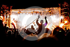 Silhouette of girl with raised hands on music concert