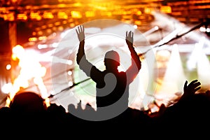 Silhouette of girl with raised hands on music concert