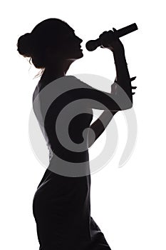 Silhouette of girl singing into microphone, profile of young woman face performing lyric song on white isolated background