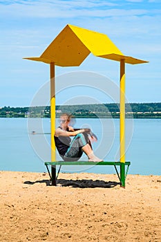 Empty beach with a bench with a canopy on the coast