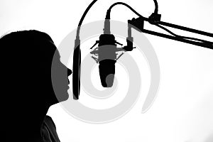 Silhouette of a girl with a studio microphone, radio presenter, singer and blogger, voice acting