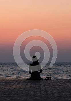 Silhouette of a girl on a sunset background sunrise on the sea