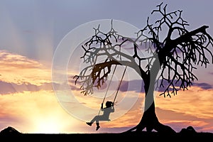 Silhouette of the girl on the swing