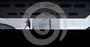 Silhouette woman walking parking lot dark building in city outdoors.