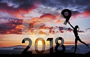 Silhouette of the girl who holds the numbers of the new year in the sunset. Concept of replacement 2018 to 2019