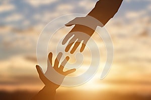 Silhouette of giving a helping hand, hope and support each other over sunset